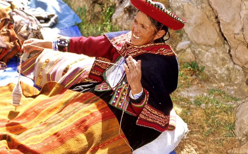 Traditionally dressed woman selling blankets in Sacred Valley market