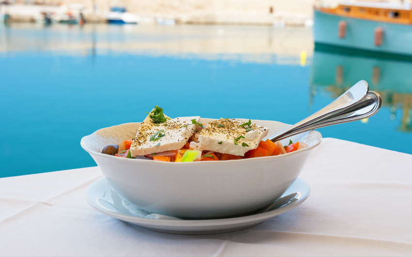 Greek salad with feta cheese on table in Crete
