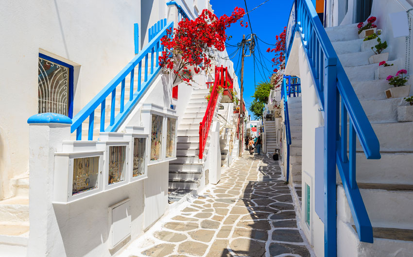 whitewashed street with blue windows in Mykonos town