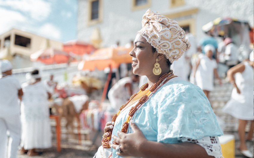 Baiana in traditional costume in front of church in Salvador